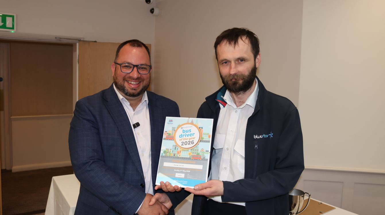 Grzeg holding a certificate stood next to GSC commercial director